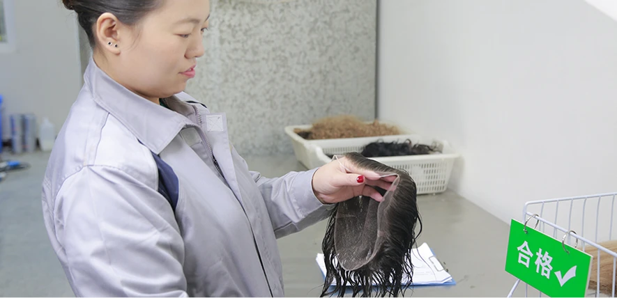 A quality checker inspecting a finished custom hair system for men at the factory